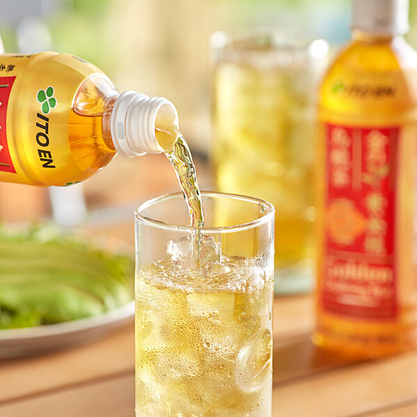 A person pouring Ito En Golden Oolong Iced Tea from a yellow plastic bottle into a glass.