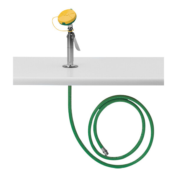 A green hose with a yellow nozzle attached to a white Haws Axion MSR eye/face wash station.