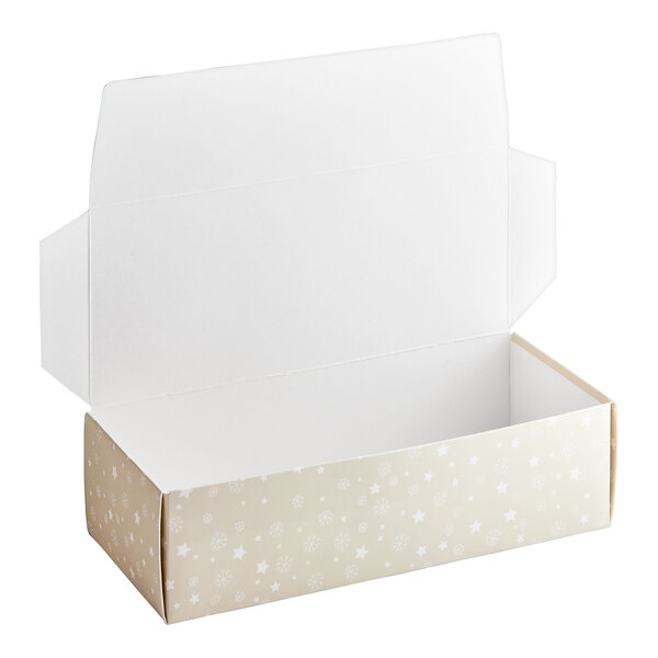 An open white Merry Christmas candy box with stars and snowflakes on the lid.
