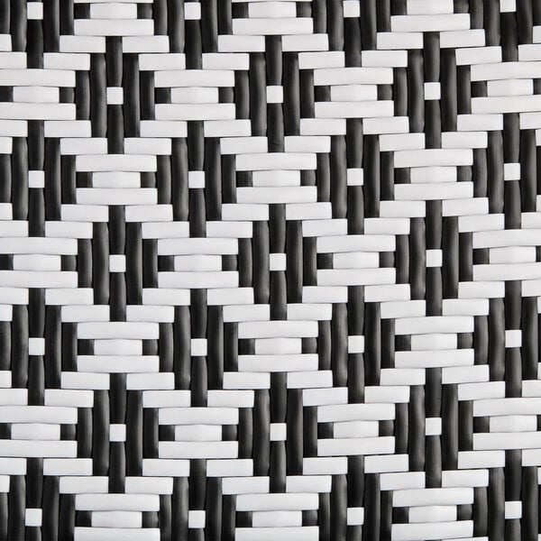A close up of a black and white woven Lancaster Table & Seating Bistro Series rattan outdoor side chair.