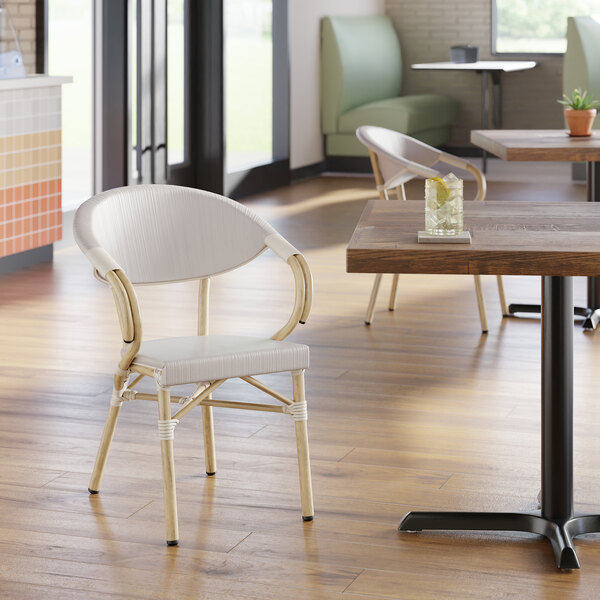 A gray outdoor arm chair with a rounded back and woven design, suitable for bistro or patio seating.