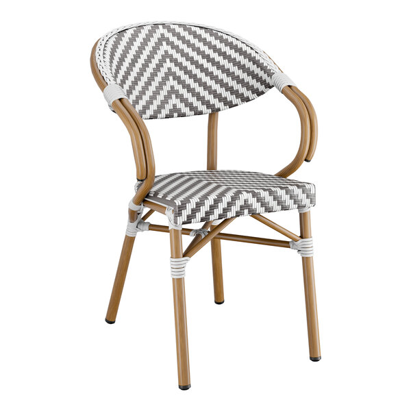 A Lancaster Table & Seating Bistro Series Rattan outdoor arm chair with a woven chevron seat in grey and white.