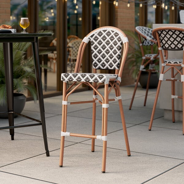 A Lancaster Table & Seating outdoor barstool with a black and white birdseye weave seat.