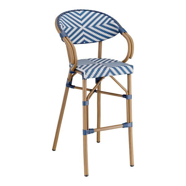 A Lancaster Table & Seating navy and white chevron weave rattan arm barstool.