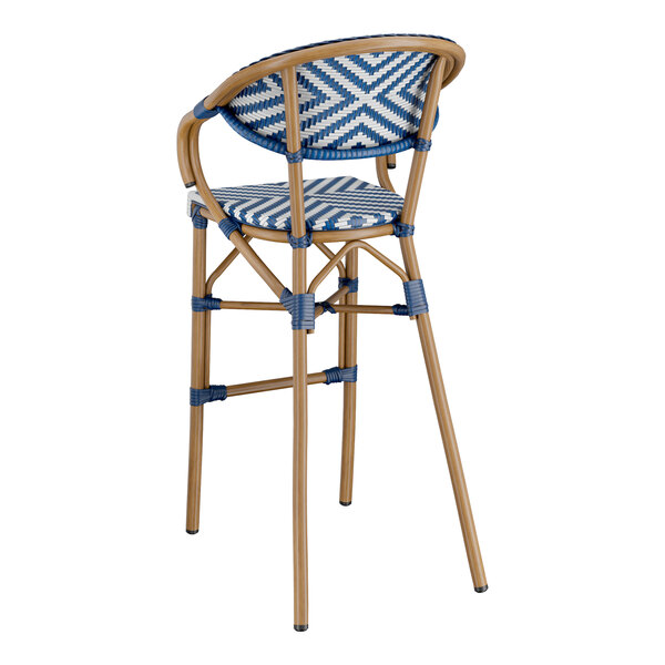 A Lancaster Table & Seating navy and white wicker arm barstool with a chevron weave pattern.
