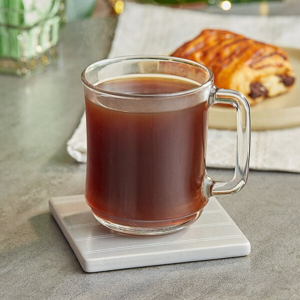 A glass mug of Nescafe Whole Bean Espresso on a coaster.