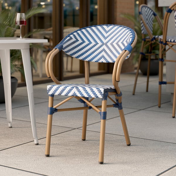 A Lancaster Table & Seating outdoor arm chair with a navy and white chevron weave pattern.