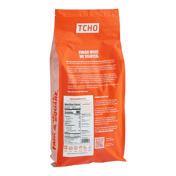 A case of TCHO Choco Charms 60.5% dark chocolate hexagons with white text on the bag.