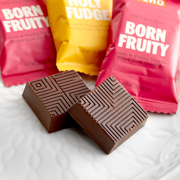 TCHO Globe Trotter assorted dark chocolate squares in pink, yellow, and chocolate packaging.