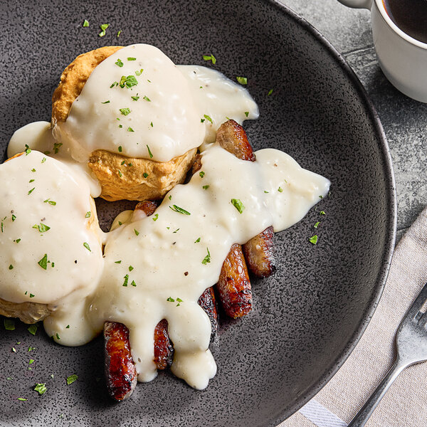 A plate with two biscuits and Trio country gravy on it with a fork.