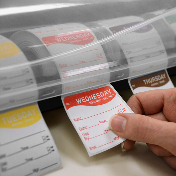 A person holding a DayMark LabelSafe 7-slot label dispenser with a roll of labels in it.