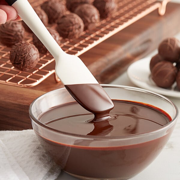 TCHO Choco Charms dark chocolate being poured into a bowl of chocolate.