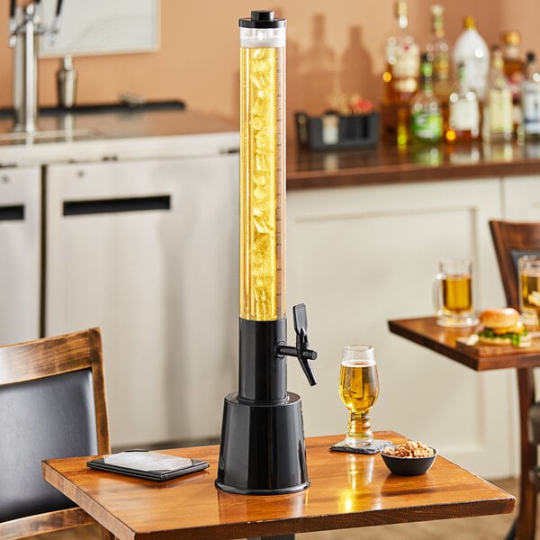 A black Choice beer tower on a wood table with food and drink.