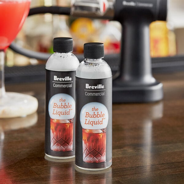 Two Breville bottles of commercial bubble liquid on a table.