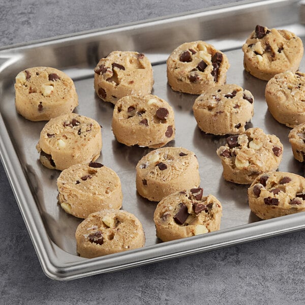 A baking tray filled with Otis Spunkmeyer triple chocolate cookies on a gray surface.