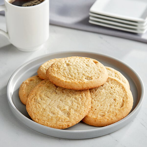 A stack of Otis Spunkmeyer sugar cookies on a white plate.