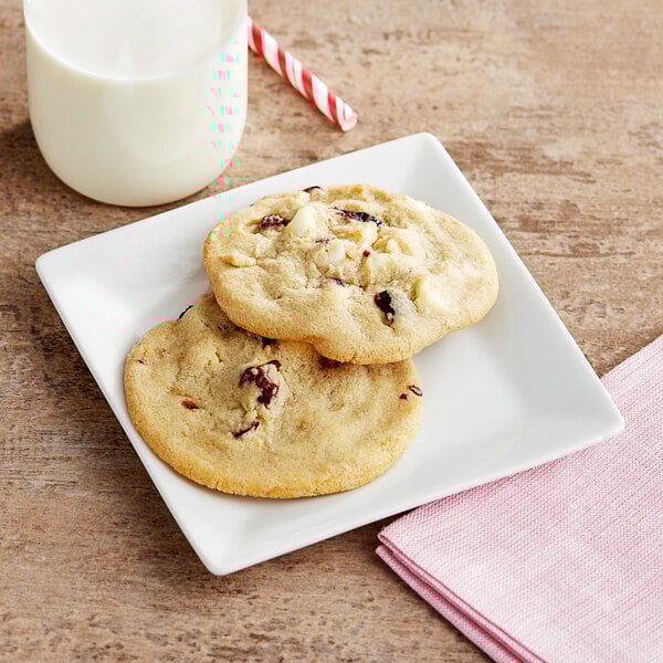 A plate of Otis Spunkmeyer strawberry shortcake cookies with a glass of milk.