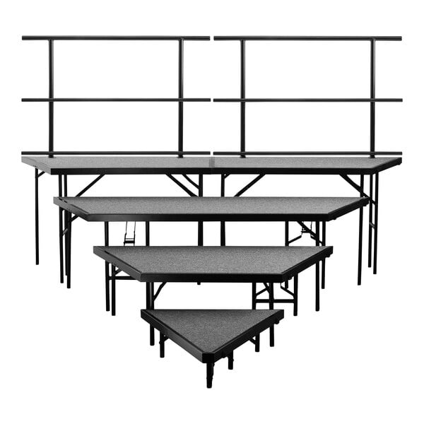 A gray National Public Seating carpeted stage riser set with guardrails.