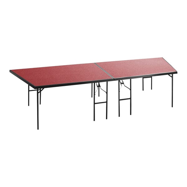 A National Public Seating rectangular red stage pie on folding legs.