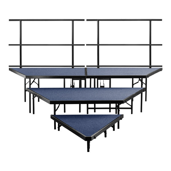 Three blue National Public Seating stage risers with black carpet.
