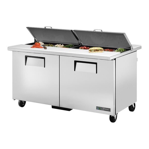 A True refrigerated sandwich prep table with food trays on a counter.