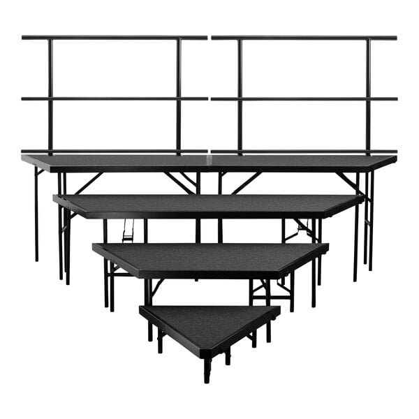 A set of three black National Public Seating stage risers with metal guardrails.