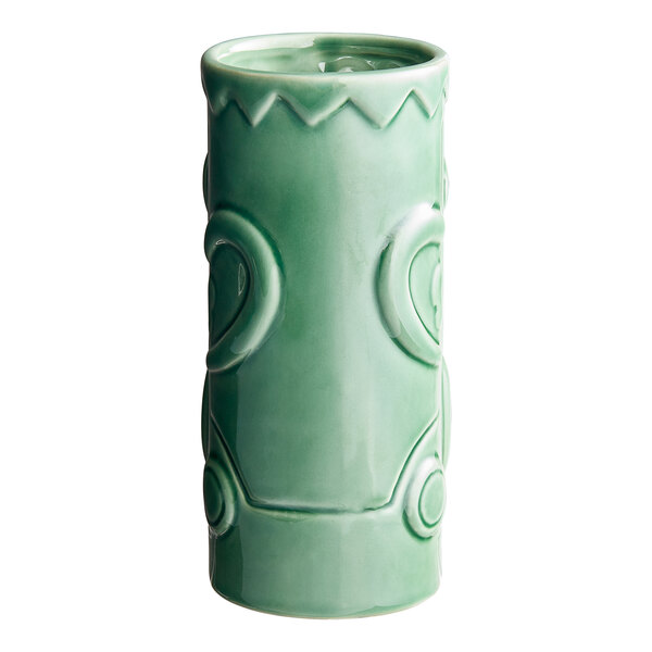 A close up of a green Acopa ceramic Tiki mug with a pattern.