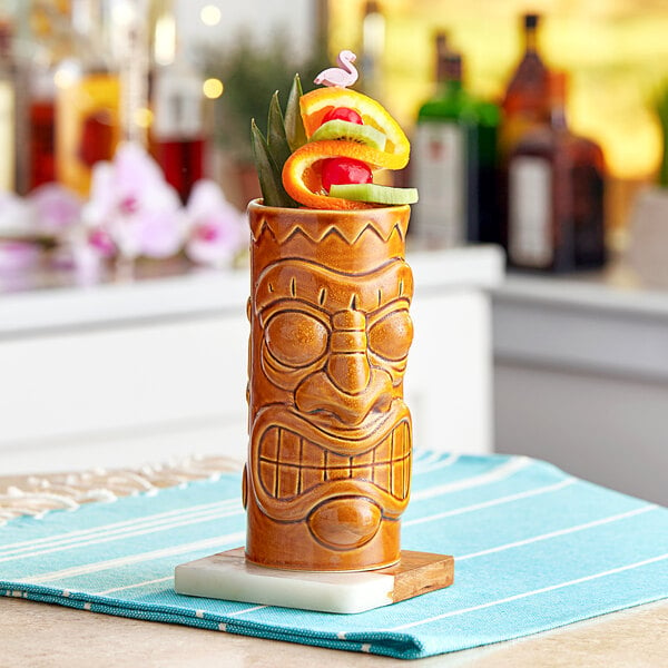 An Acopa ceramic tiki mug with fruit on top.