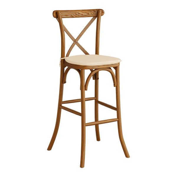 A Lancaster Table & Seating outdoor bar stool with a tan cushion on the seat.