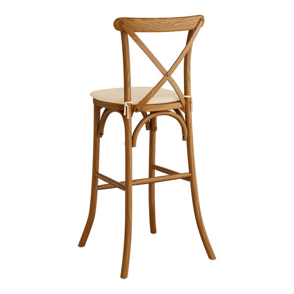 A Lancaster Table & Seating Vineyard Series wooden outdoor bar stool with a Chardonnay tan cushion.