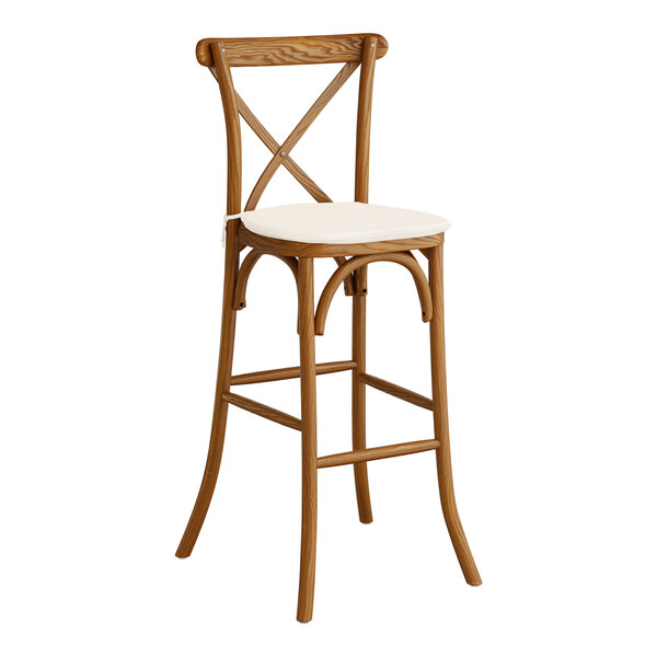 A Lancaster Table & Seating wooden bar stool with a white cushion.