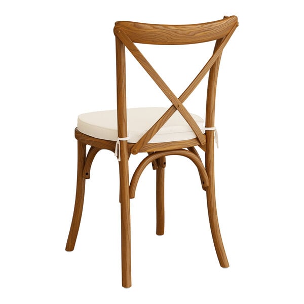 A Lancaster Table & Seating outdoor cross back chair with a white cushion.