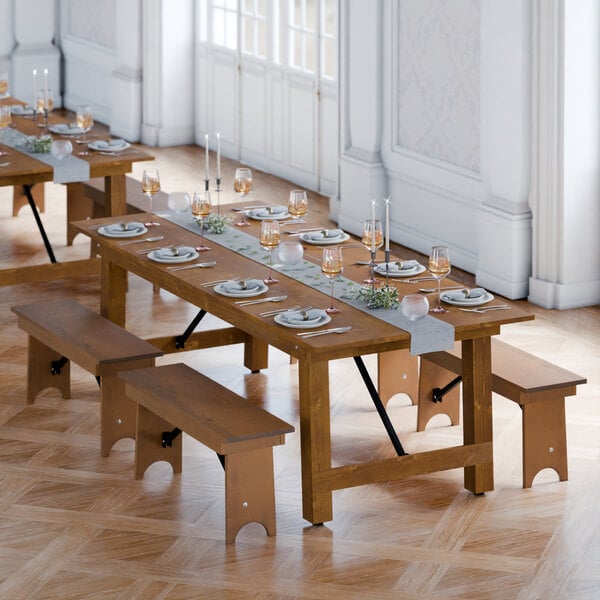 A Lancaster Table & Seating Vineyard Series barrel brown table with plates and glasses on it and wooden benches.