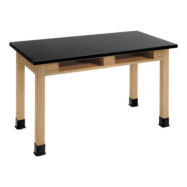 A black National Public Seating science lab table with wood legs and built-in book compartments.