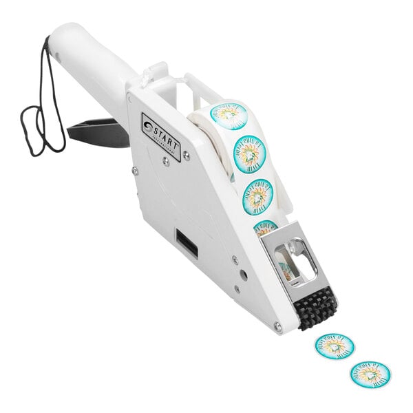 A white Start International manual label applicator with blue stickers on it.