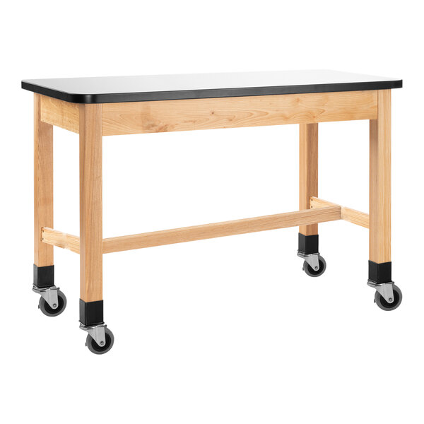 A wooden science lab table with black and whiteboard tops and wheels.