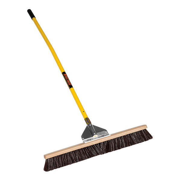 A Structron general purpose push broom with a yellow handle.
