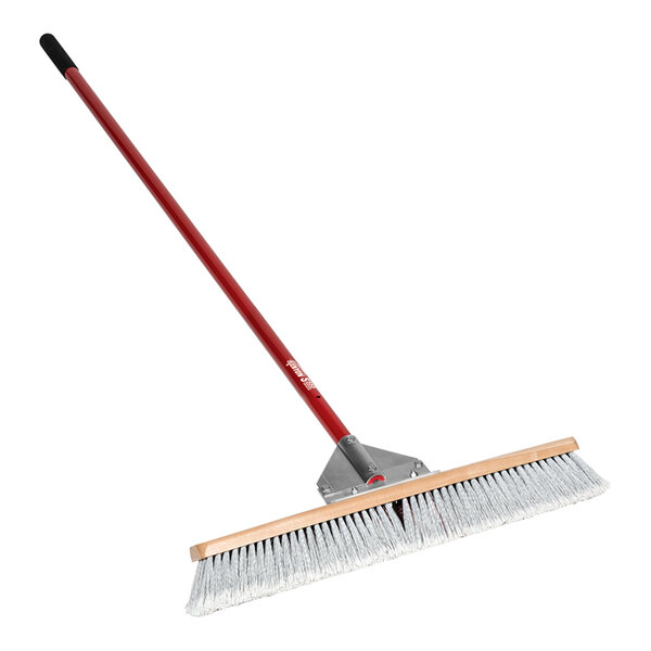 A Kenyon Wonder / Duo push broom with a red and white head and a long aluminum handle.
