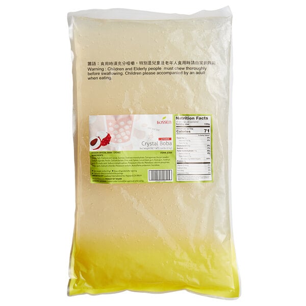 A bag of Bossen Lychee Crystal Boba in syrup with yellow liquid.