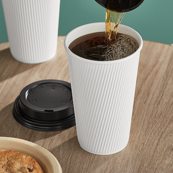 A cup of coffee being poured into a white Choice paper hot cup.