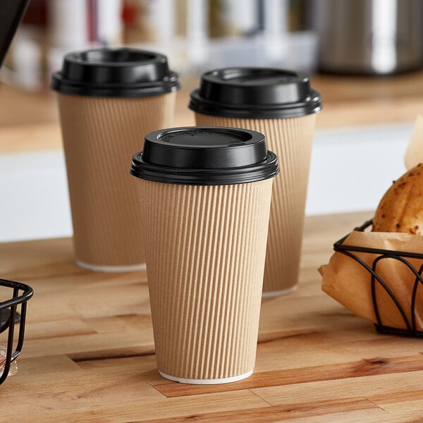 Choice paper hot cups and lids on a counter in a coffee shop.