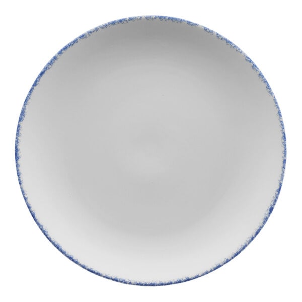 A white porcelain coupe plate with blue speckles and a blue rim.