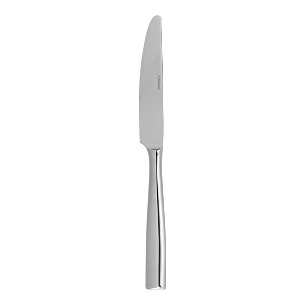 An Arcoroc stainless steel dinner knife with a silver handle.