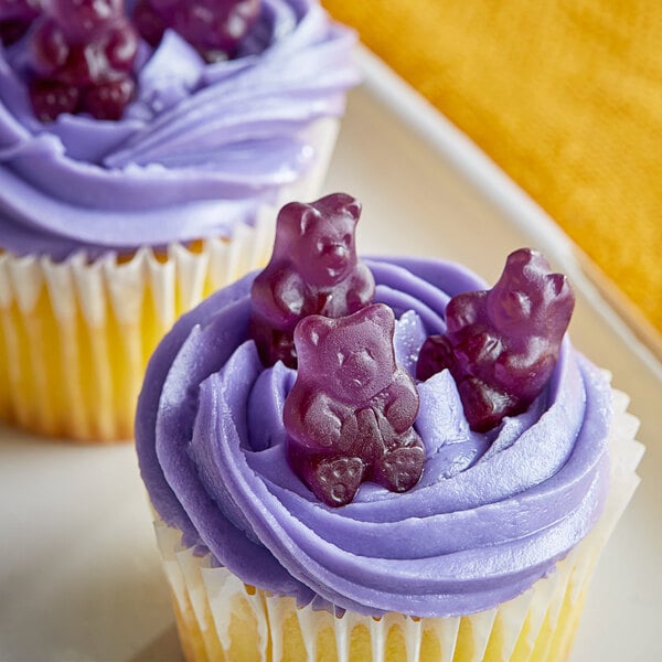 A cupcake with purple frosting and Albanese grape gummy bears on top.