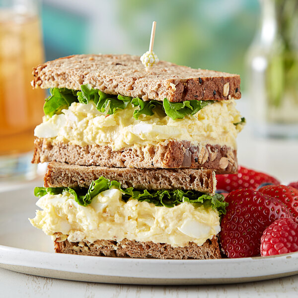 A sandwich with egg salad and lettuce on a plate.