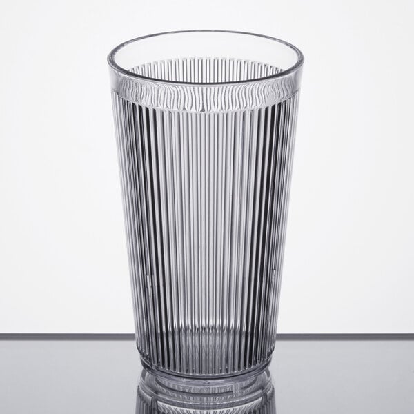 A close-up of a Carlisle clear plastic tumbler with a straight rim.
