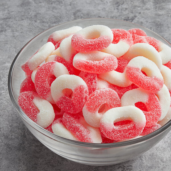 A bowl filled with red and white Albanese Watermelon Gummi Rings.