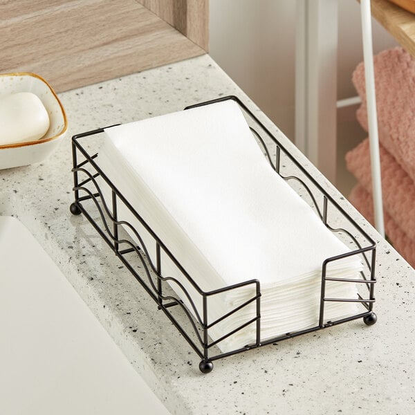 A black metal tray with white Lavex Linen-Feel guest towels on a counter.