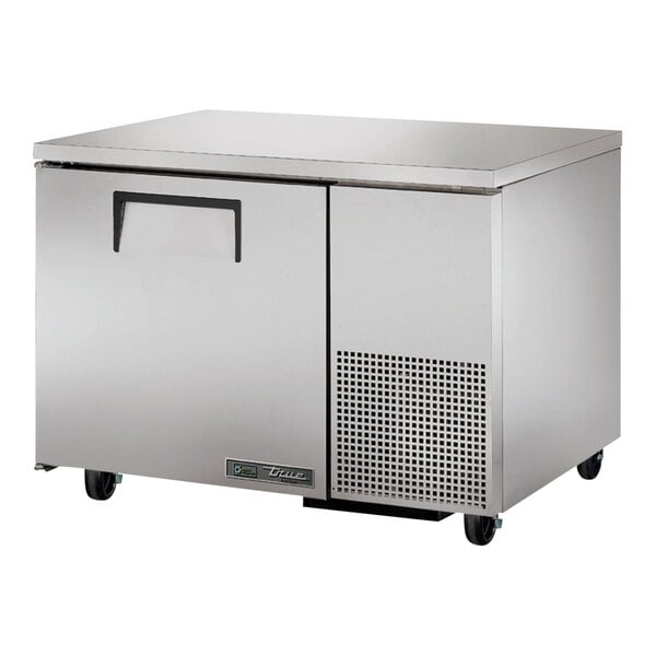 A stainless steel True undercounter freezer with wheels.