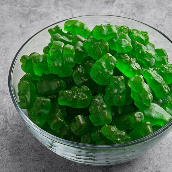 A bowl of Albanese green apple gummy bears on a table.